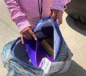 Student puts donated supplies in backpack