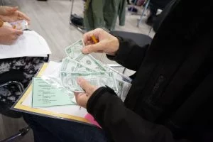 A person's hands sorting bills of cash