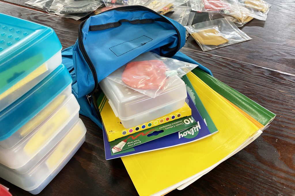 A backpack sits open on display with school supplies