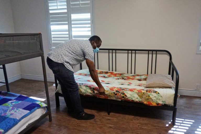 A volunteer arranges a shelter bed.