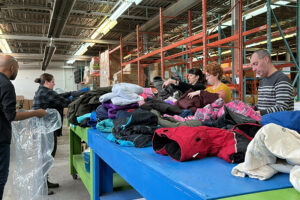 a group of volunteers sort donated coats at United Way's In Kind Exchange