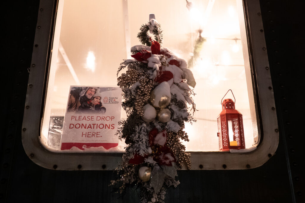 Christmas decorations and coats donation sign in train window