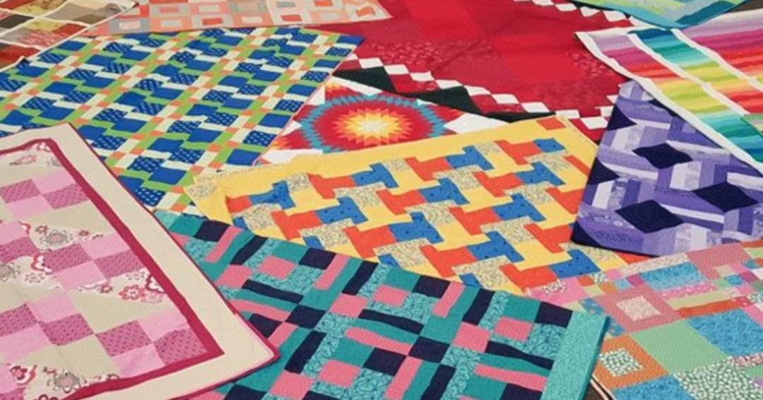 A patchwork of brightly coloured quilts fill the frame