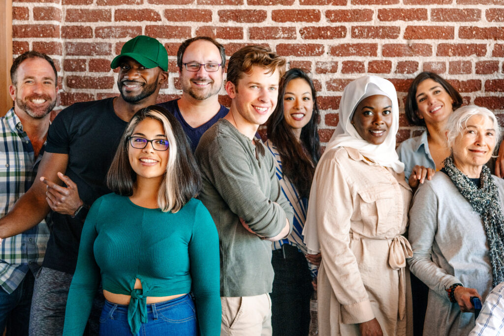 Group of diverse people standing in front of a brick wall