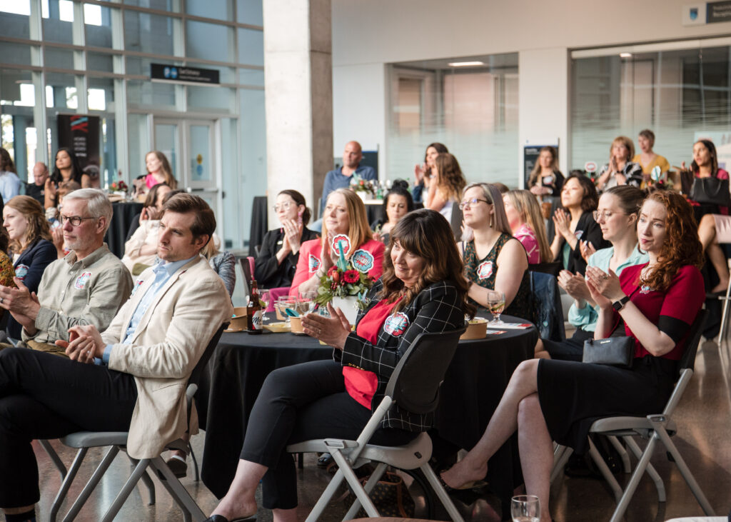 Group of Women United supporters engaged in the audience watching a panel of speakers discussing the impact Women United has had in the lives of local women and girls at the Power of Women event in 2023, hosted by Women United.