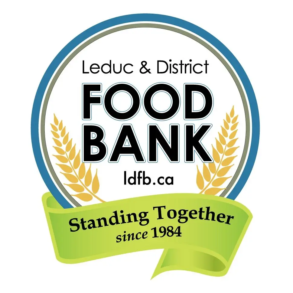 Leduc & District Food Bank logo featuring the organization's name in bold, uppercase letters, flanked by two stylized golden wheat stalks, all enclosed within a circular border, symbolizing nourishment and community support.